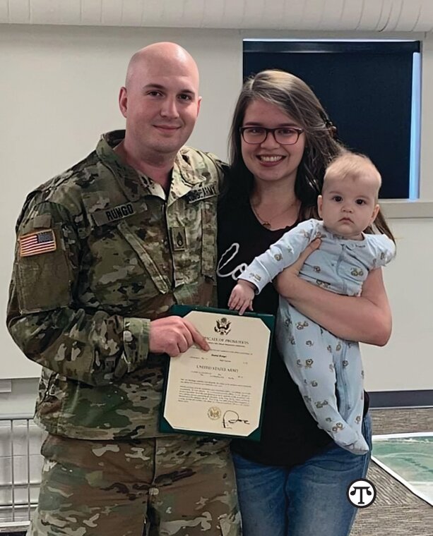 Daniel Rungo takes a family photo with his wife and daughter after his enlistment ceremony with the U.S. Army.